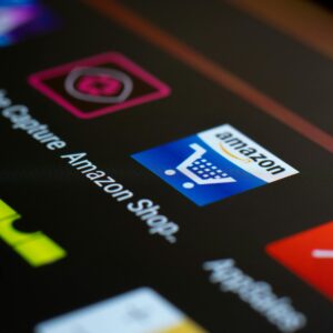 Close-up of the Amazon shopping app icon on a smartphone screen. Ideal for online shopping and technology themes.